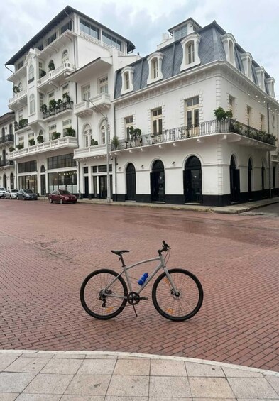 A white building with balconies and a bicycle parked on the street. 3