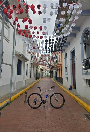 A street with a bicycle parked on the side, decorated with hanging cups. 2