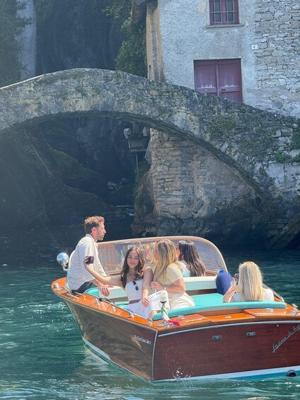 A boat with people on it, a stone bridge, and a building with a number '4' sign. 4