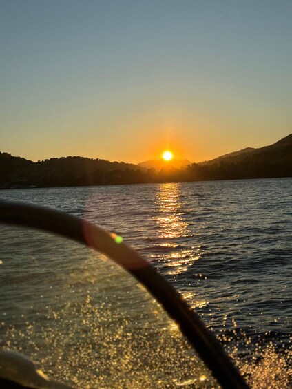 A sunset over a body of water with a boat in the foreground. 2