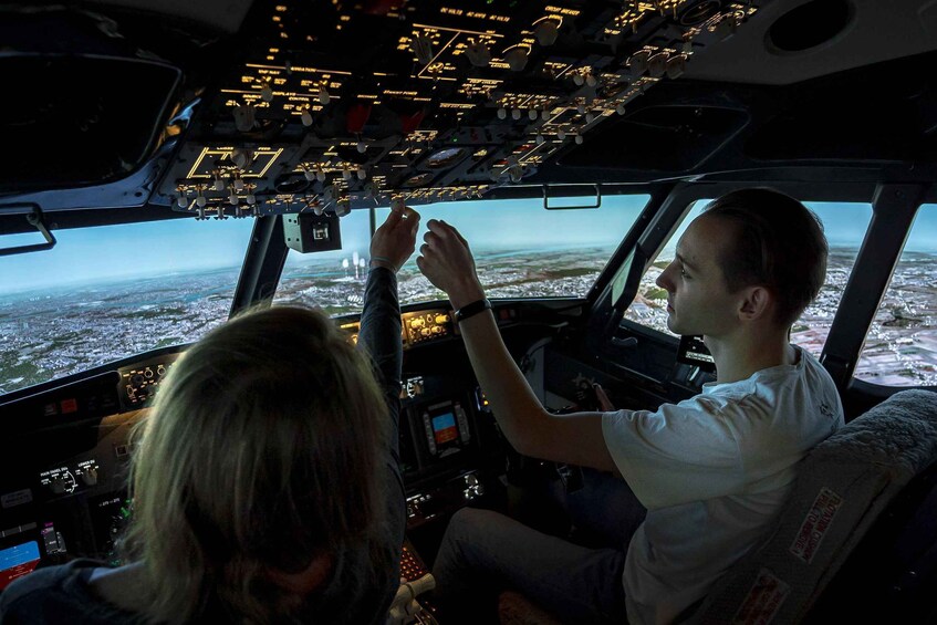 A cockpit with a view of a cityscape through the windshield. 2