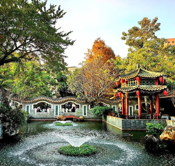 A traditional Chinese pavilion over a koi pond with a stone bridge. 1