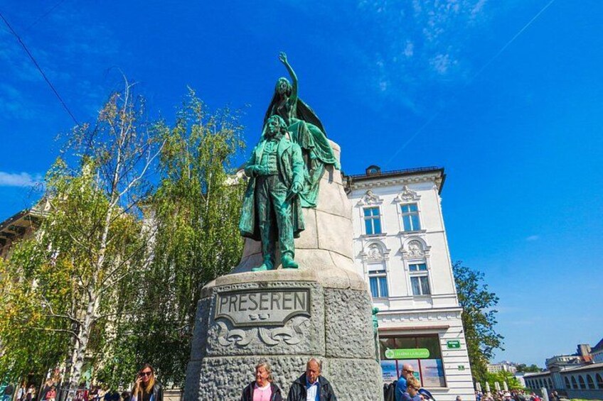 A statue of a historical figure with a pedestal labeled 'PRESERVEEN' in a public square with buildings in the background. 3