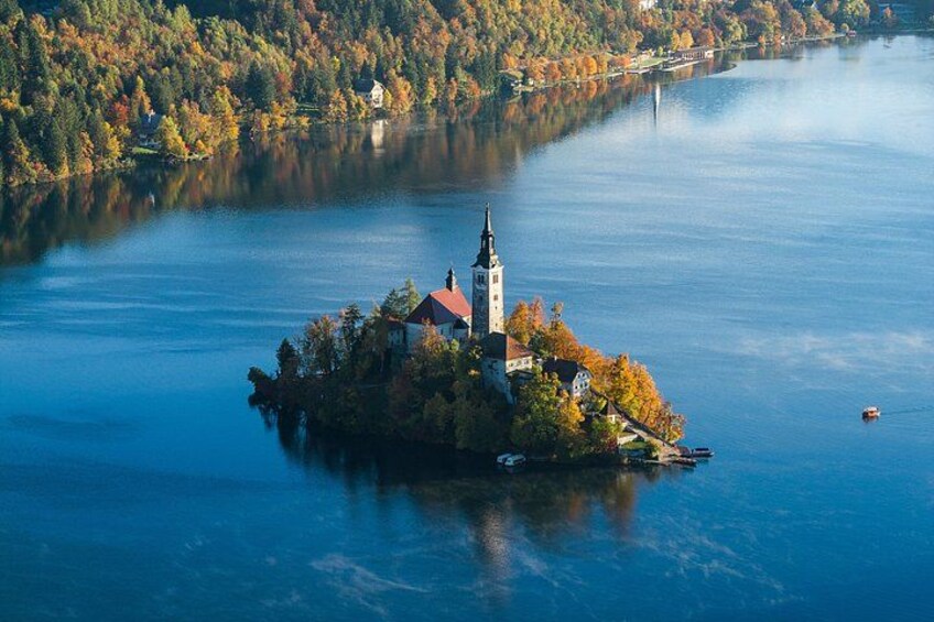 An island with a church, surrounded by autumn-colored trees and a calm lake. 2