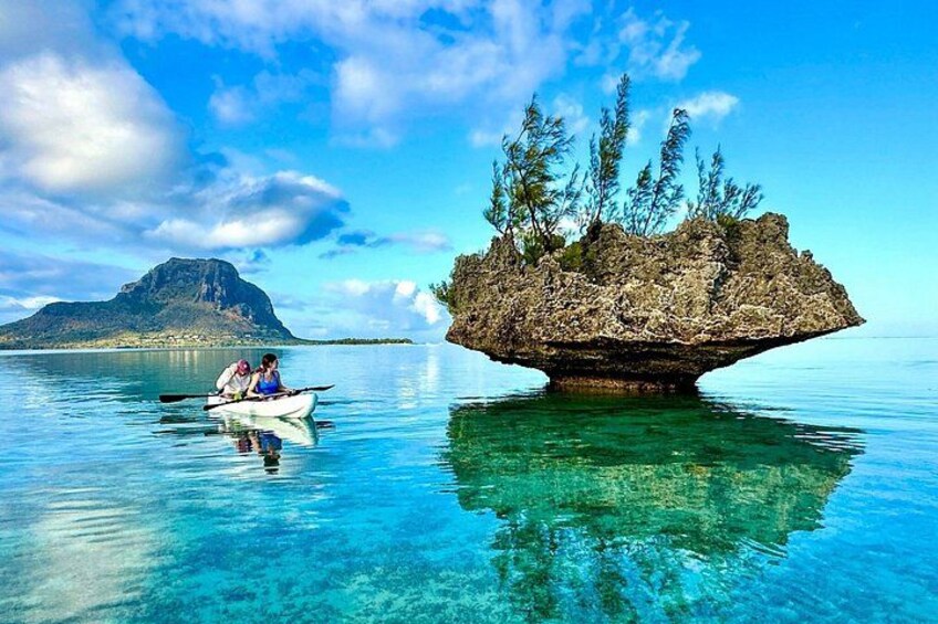A clear blue sea with a small island and a distant mountain. 4