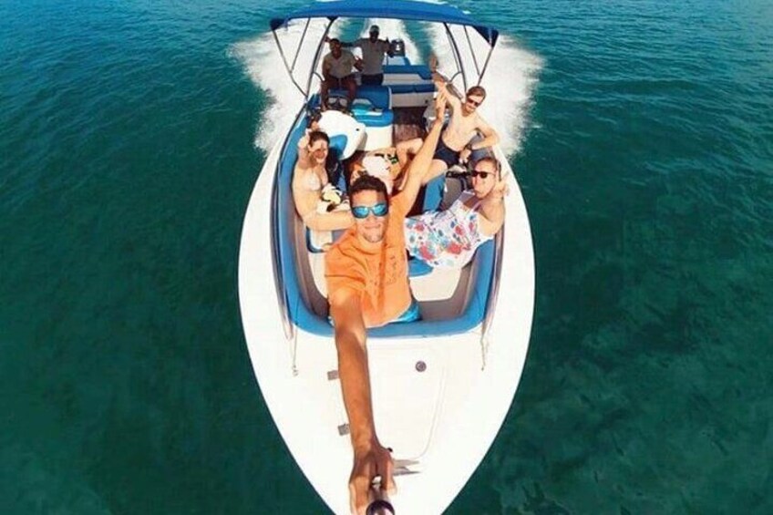A boat with people on it, surrounded by clear blue water. 5