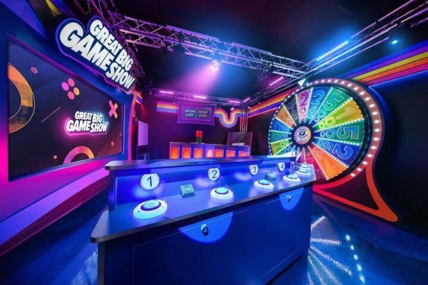 A game show set with a wheel, podium, and illuminated numbers. 5