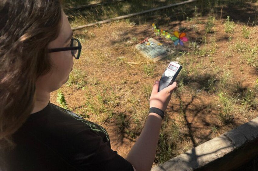 A person holding a smartphone, looking at a book on the ground. 4