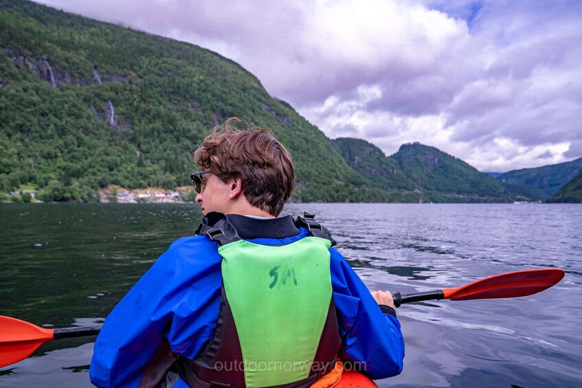 A person kayaking on a lake with mountains in the background. 3