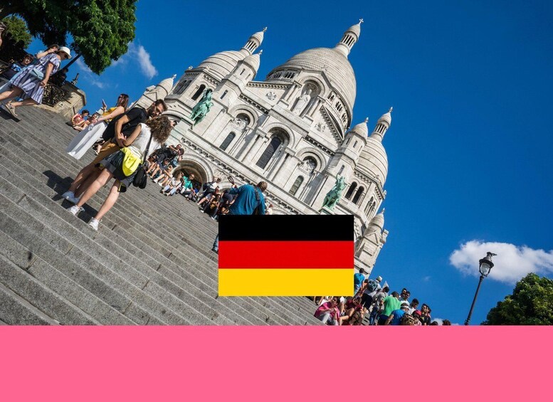 A crowd ascending steps towards a large domed building with statues, under a clear blue sky. 1