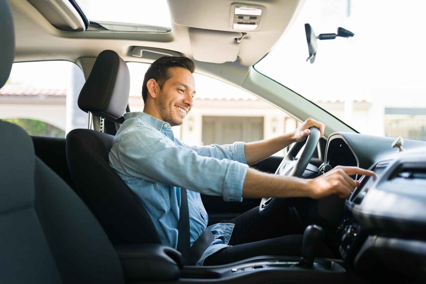 A person driving a car, steering wheel visible, and car interior. 2