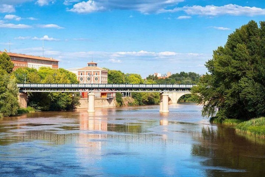 A river with a bridge, buildings, and trees. 3
