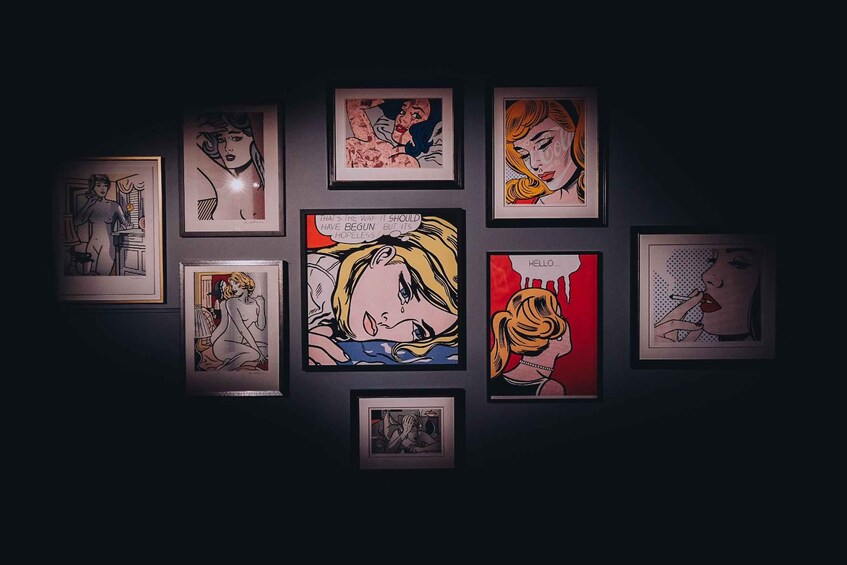 A collection of framed pop art prints on a dark wall. 4