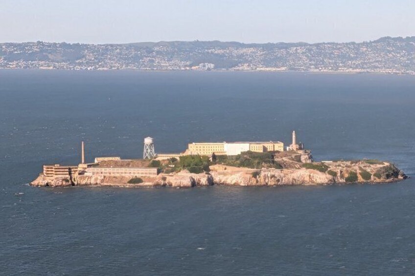 A coastal fortification with a lighthouse, water tower, and a prominent building on a rocky island. 2