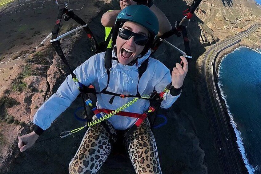 A person skydiving with a parachute, wearing a helmet and goggles, and a leopard print outfit. 4