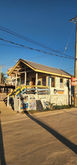 A building with a yellow staircase, a sign for Blackhawk Tours, and a white fence. 2