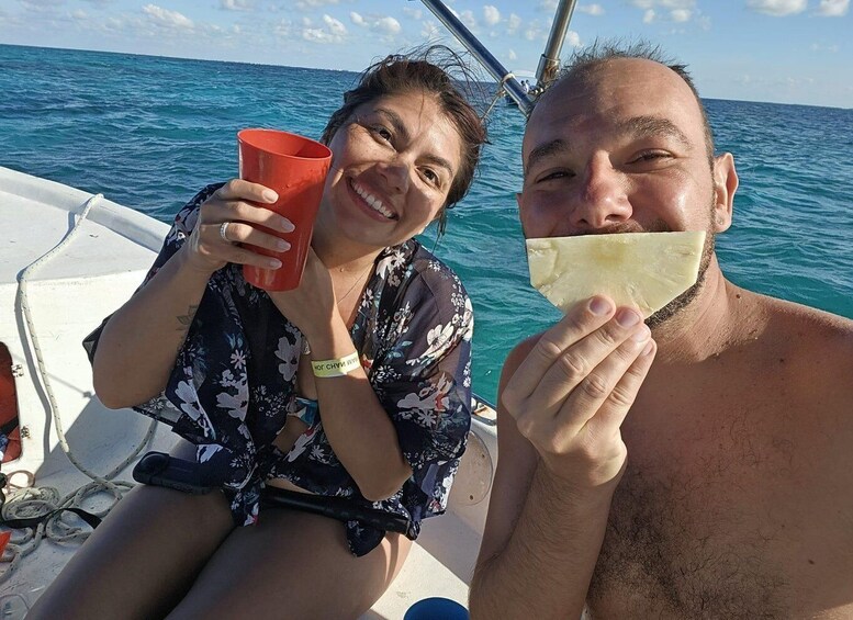 Two people on a boat, one holding a red cup and the other holding a piece of bread. 5