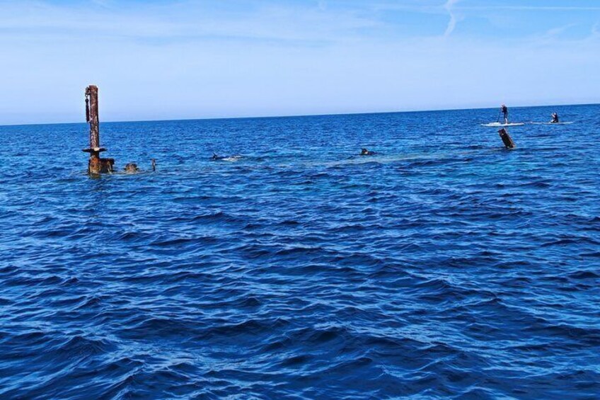 A calm sea with a buoy and a person on a surfboard. 5