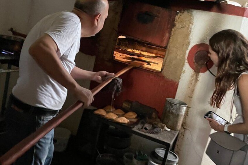 A man and a woman in a kitchen with a bread oven. 4