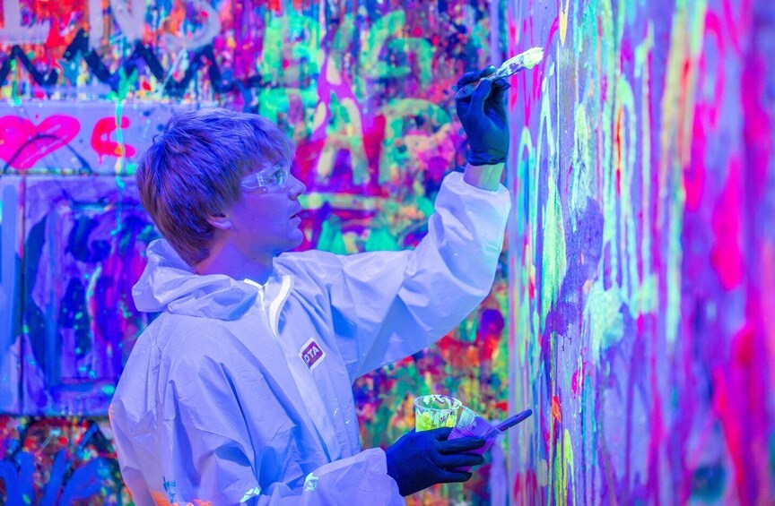 Una persona dipinge un muro con colori vivaci. 1