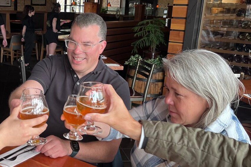 Two people toasting with beer glasses at a restaurant. 5