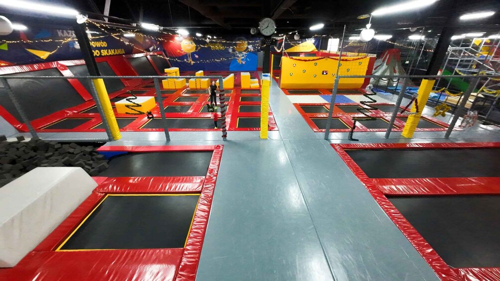An indoor trampoline park with multiple trampolines, padded safety areas, and colorful decorations. 5