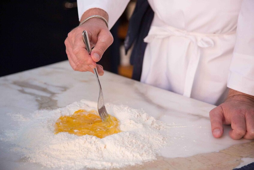 A person mixing ingredients on a marble surface. 5