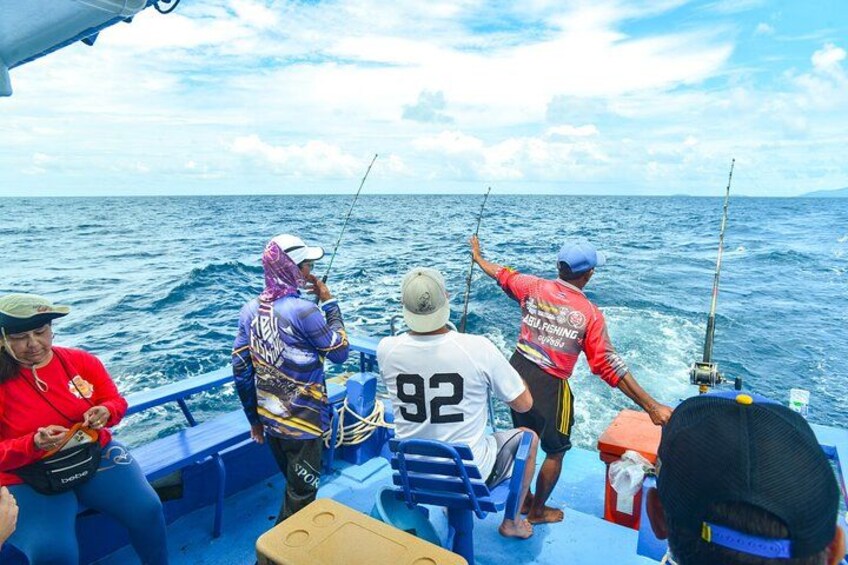 People on a boat fishing in the ocean. 2