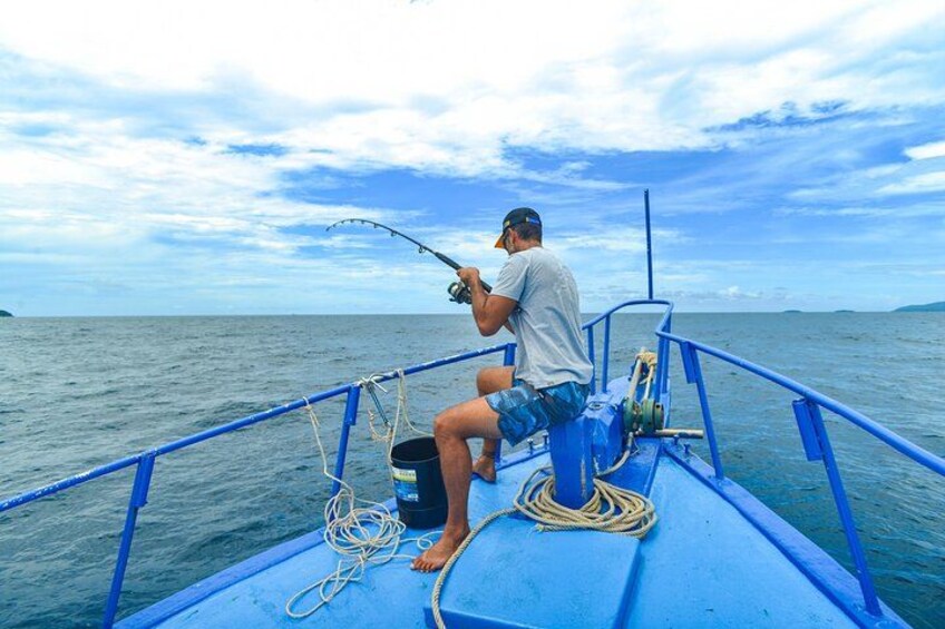 A person fishing on a boat with a calm sea and a clear sky. 3