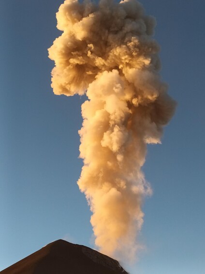 A large plume of smoke rising against a clear sky. 2