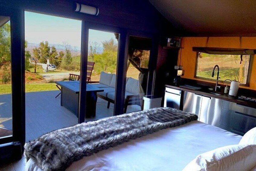A bedroom with a bed, a window, and a view of a vehicle outside. 1