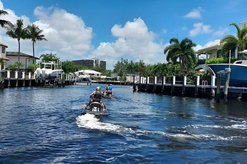 A waterway with boats, palm trees, and waterfront buildings. 5