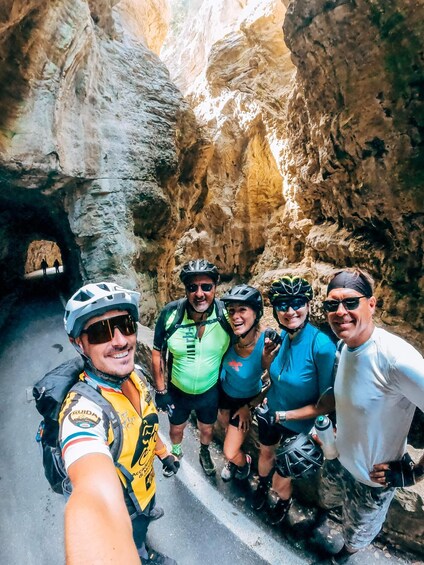 A group of cyclists in a rocky canyon with a narrow passageway. 3