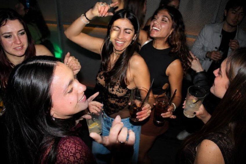 A group of people at a social gathering, holding drinks and engaging in conversation. 1