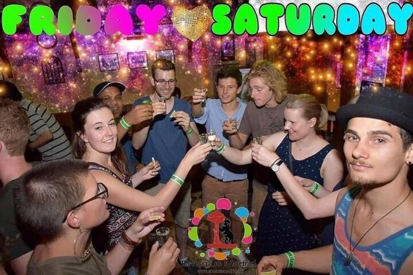 A group of people celebrating with drinks, surrounded by colorful decorations and a disco ball. 2