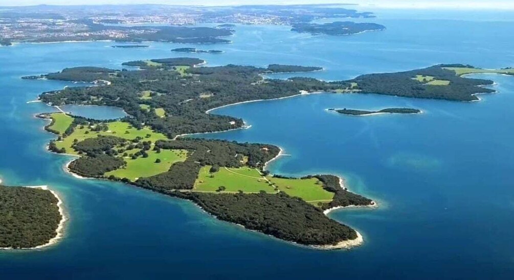 An aerial view of a chain of islands with clear blue waters and green vegetation. 1