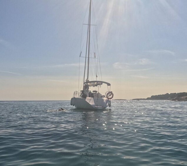A sailboat on calm waters with a clear sky. 5