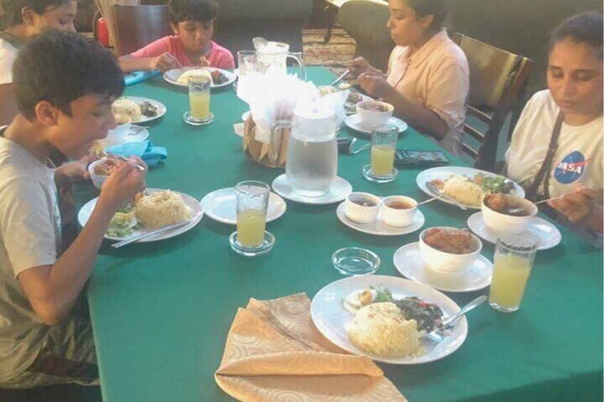 People dining at a table with various dishes and drinks. 2