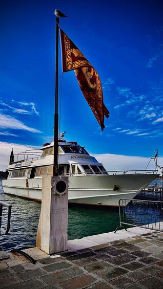 A boat named 'ROMINA' docked at a pier with a flag featuring a golden lion. 2