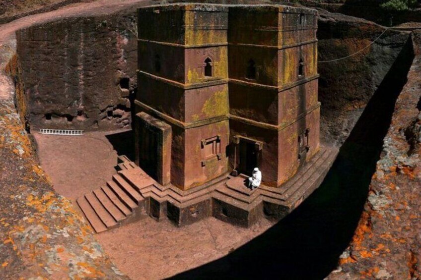 A multi-tiered ancient structure with a staircase leading up to it, surrounded by rocky terrain. 4