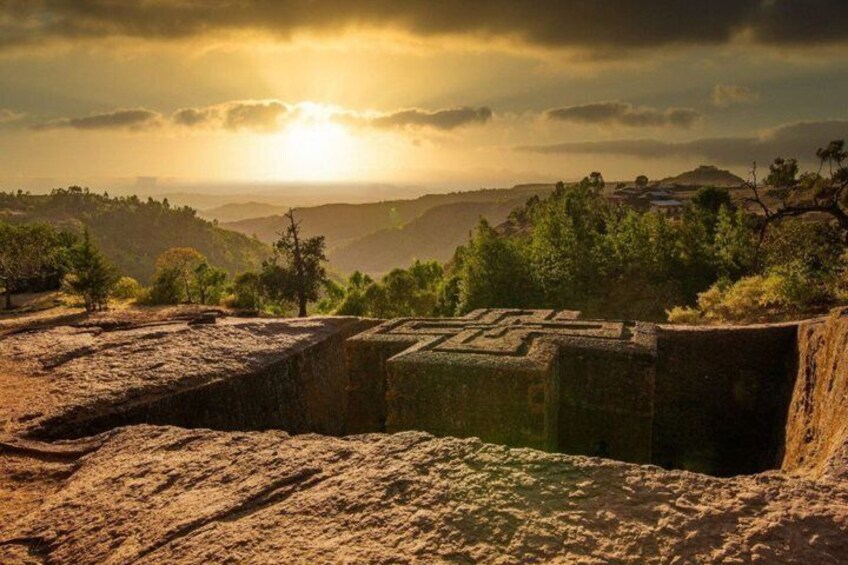 A stone structure with a sunlit landscape in the background. 3
