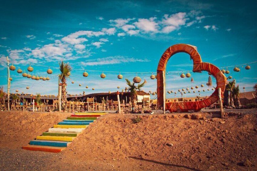 A desert landscape with a colorful staircase leading to a heart-shaped archway. 5