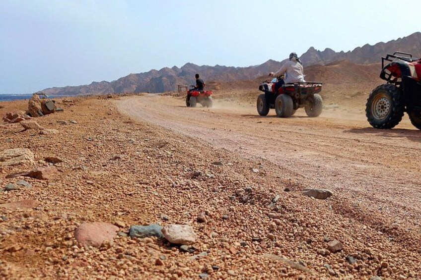 A rocky terrain with three off-road vehicles. 2