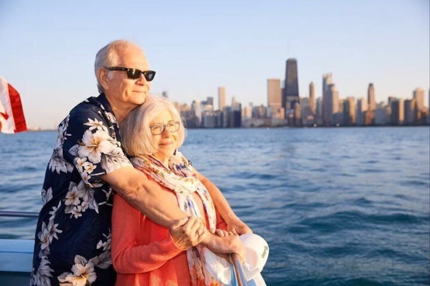 Two people embracing on a boat with a city skyline in the background. 5