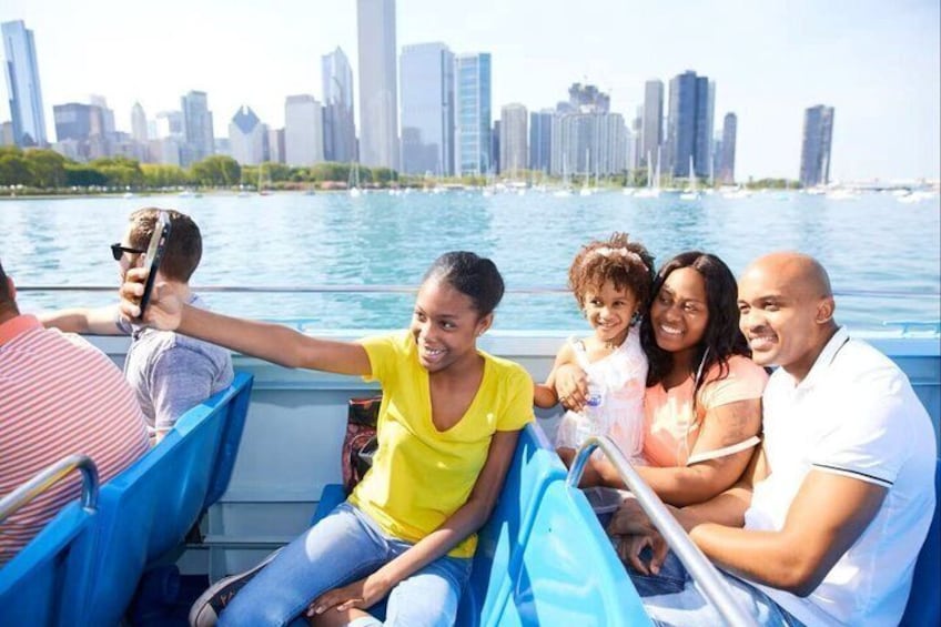 A group of people on a boat with a city skyline in the background. 4