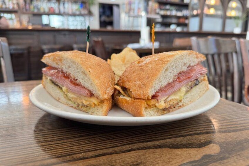 A sandwich with toothpicks on a plate, in a restaurant setting. 4