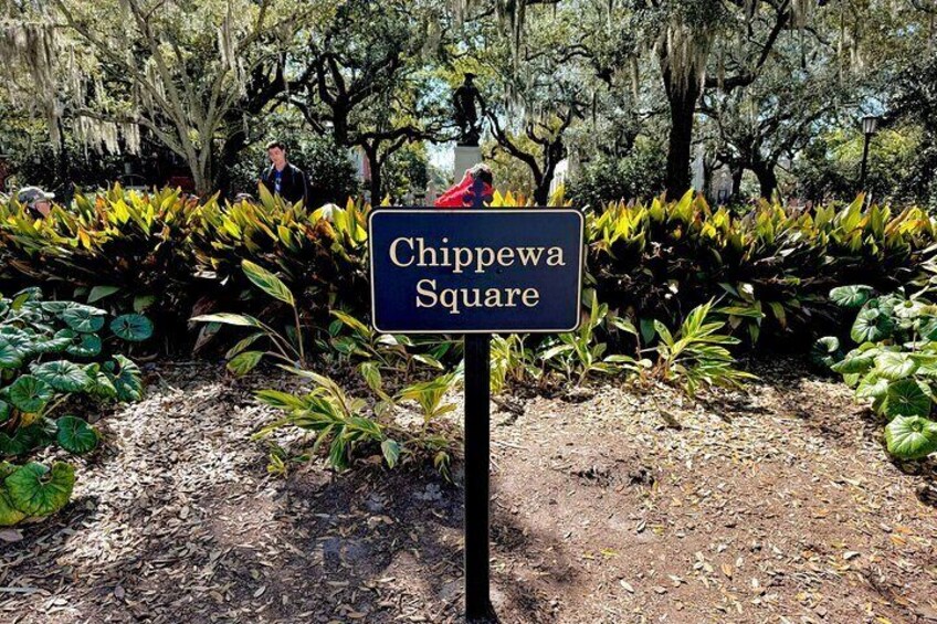 A sign reading 'Chippewa Square' with a garden and trees in the background. 3