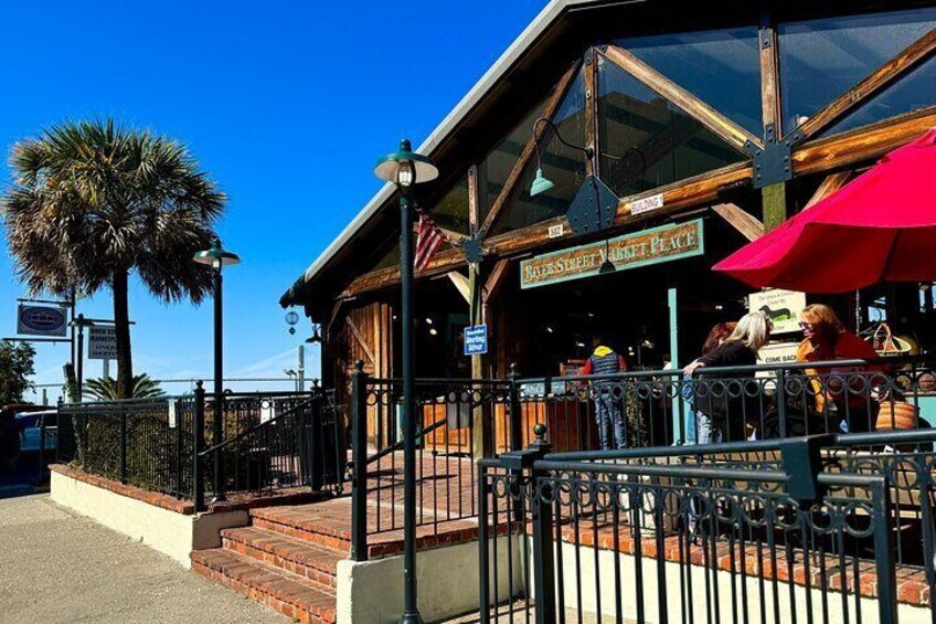 A restaurant with outdoor seating, palm trees, and a clear blue sky. 2