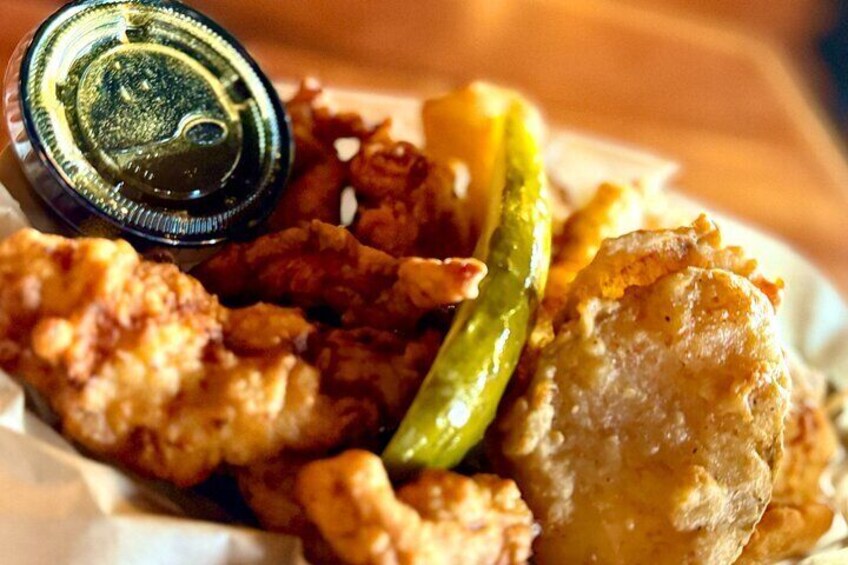 A plate of fried chicken, green chili, and a side of sauce. 1