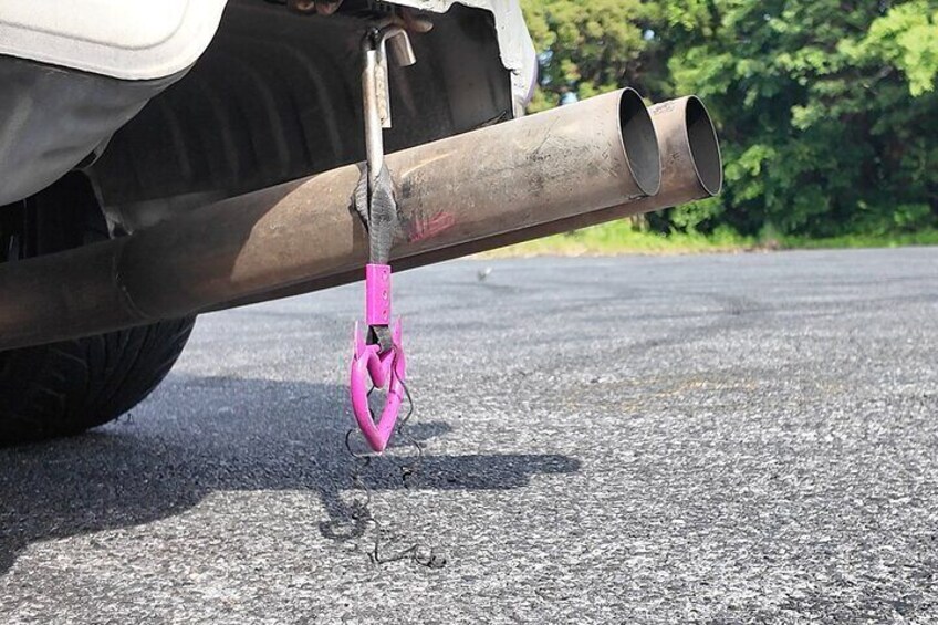 A vehicle's exhaust pipe with a pink clamp. 2